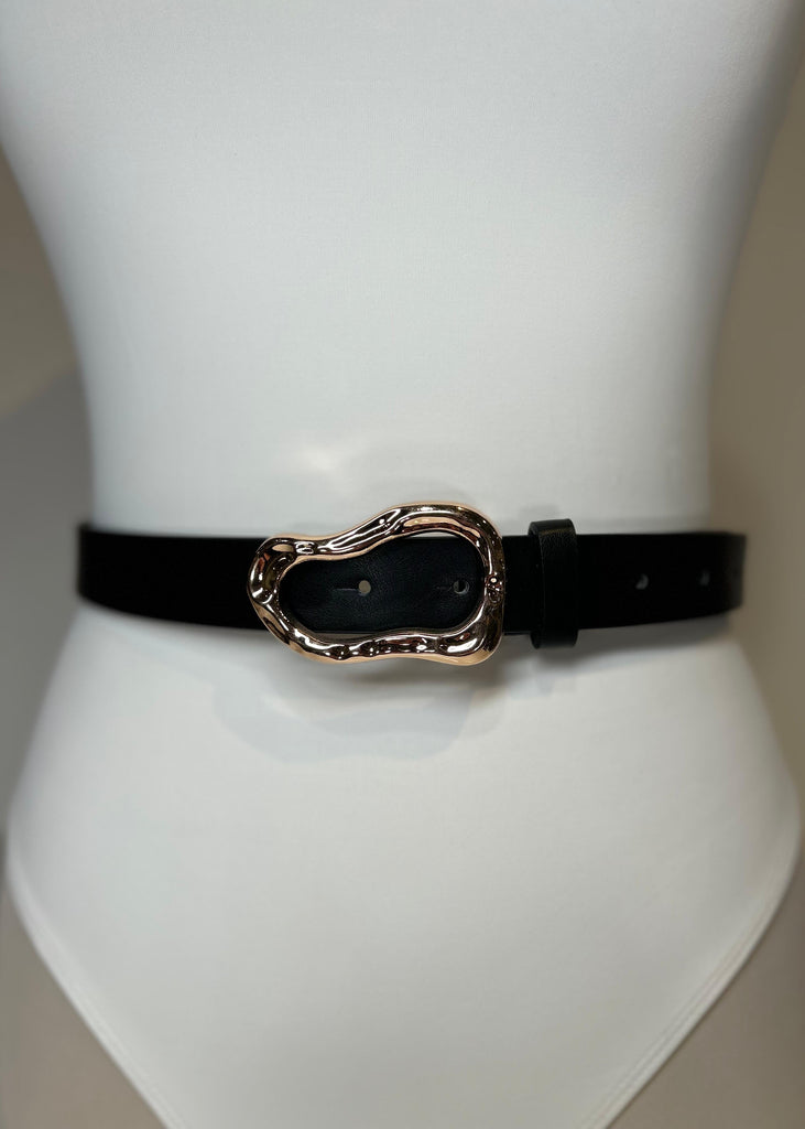 Black belt with a gold buckle on a mannequin against a neutral background